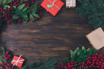 Top above high angle view photo of composition of festive objects giftboxes mistletoe berry christmas tree leaves ornaments laying on wooden brown table background