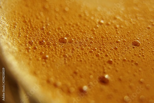 macro close-up coffee bubbles texture background, espresso foam, Macro tilt up of espresso coffee poured in a cup and swirling with its cream and aroma. Italian coffee and drink. 