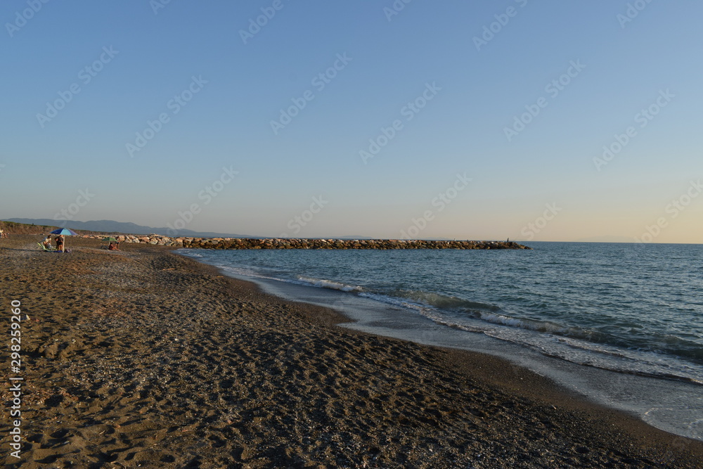 Beach, sea and pinewood on the seaside in Marina di Cecina, Tuscany, Italy. Panoramic view of the coast with pinewood, clear blue water and nice sand in a summer day Beach, sea and pinewood on the seaside in Marina di Cecina, Tuscany, Italy. Panoramic view of the coast with pinewood, clear blue water and nice sand in a summer day