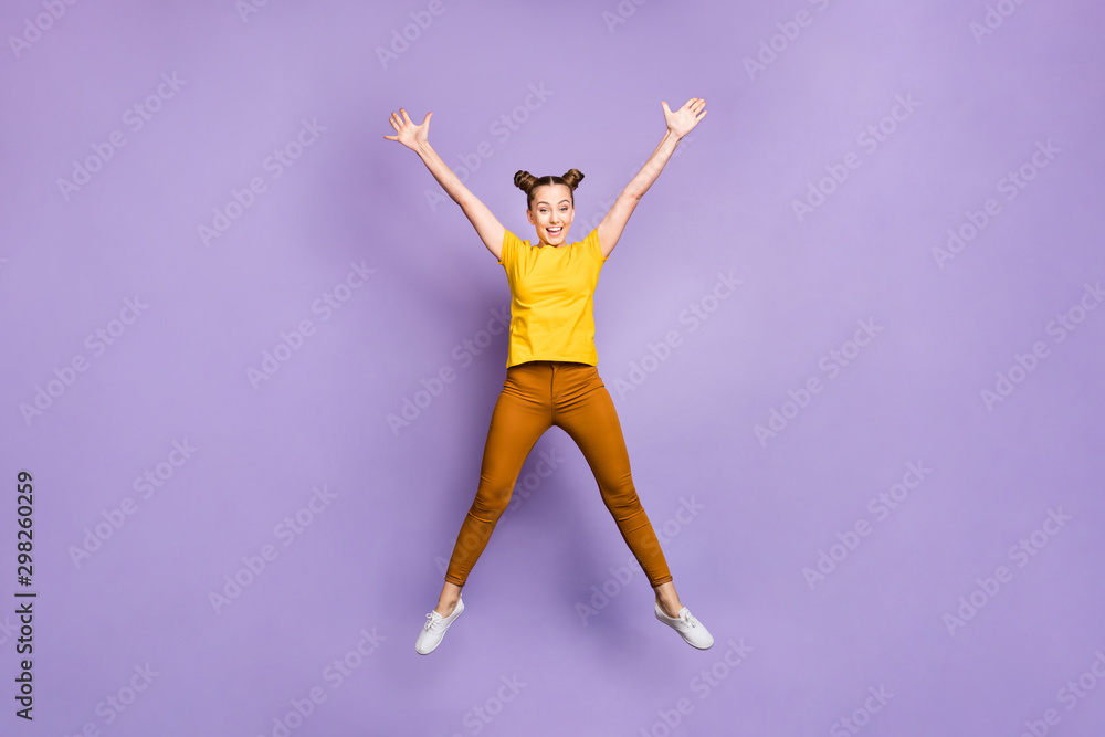 Full length body size photo of cheerful funny beautiful positive attractive girl jumping up pretending to be star wearing brown pants trousers yellow t-shirt isolated over violet pastel color Full length body size photo of cheerful funny beautiful positive attractive girl jumping up pretending to be star wearing brown pants trousers yellow t-shirt isolated over violet pastel color