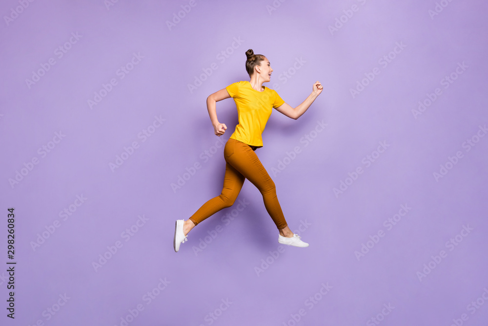 Full length profile photo of amazing lady jumping high rushing to finish line championship race wear yellow t-shirt pants isolated pastel purple background