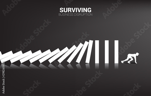 surviving business disruption. Silhouette of businessman ready to run away from domino collapse. Concept of business industry disrupt