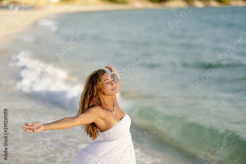 Carefree woman with arms outstretched standing at the shore.