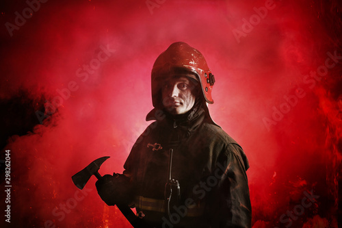 Portrait of firefighter in uniform on dark red background