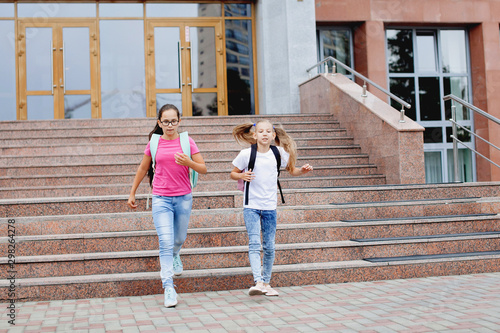 Two schoolgirl with backpacks.