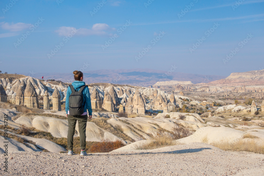Female traveler looking into the distance, enjoying the travel and life. Tourist lifestyle concept. Cappadocia, Turkey.