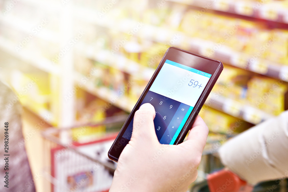 Calculator on smartphone in hand of customer Calculator on smartphone in hand of customer