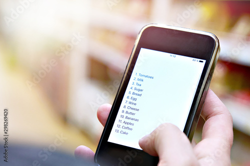 Shopping list on smartphone in hand of customer