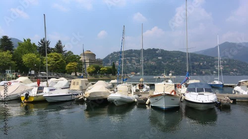 boats moored on como lake near the temple of Alessandro Volta in a sunny day photo