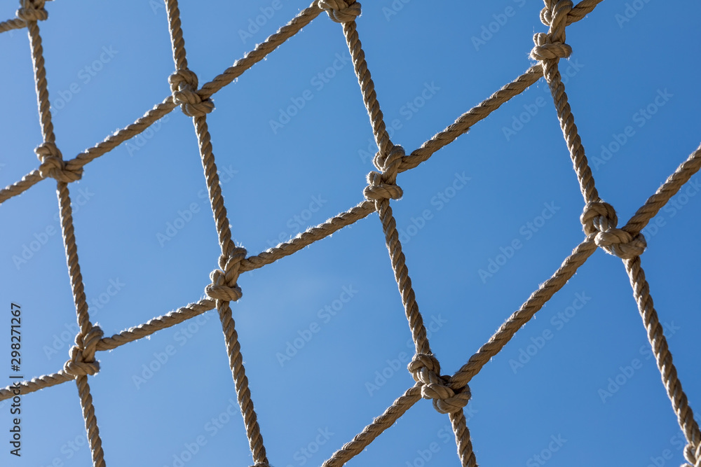 Close up of rope net against blue sky. Part of obstacle courses  in adventure park