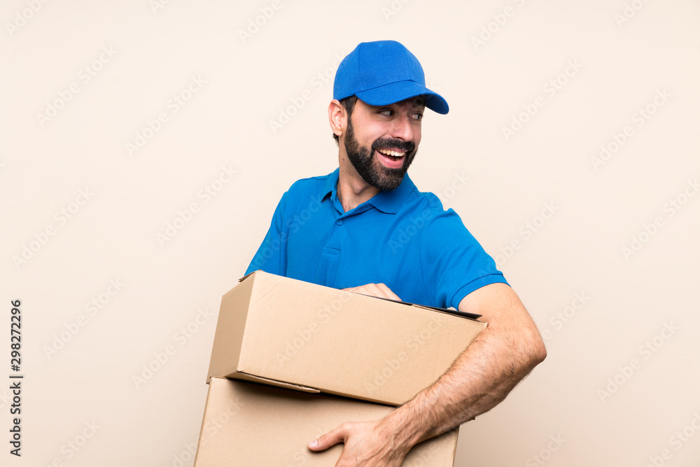 Delivery man with beard over isolated background with arms crossed and happy Delivery man with beard over isolated background with arms crossed and happy