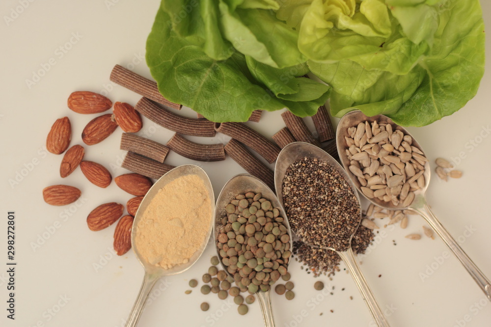 Sample foods from low-GI PCOS (Polycystic Ovary Syndrome) diet. Lentils, maca powder, chia seeds, sunflower seeds, buckwheat pasta, almonds and lettuce.