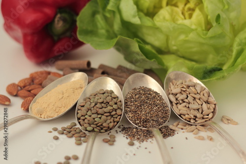 Obraz na płótnie Sample foods from low-GI PCOS (Polycystic Ovary Syndrome) diet. Lentils, maca powder, chia seeds, sunflower seeds, buckwheat pasta, almonds, bell pepper and lettuce. w salonie