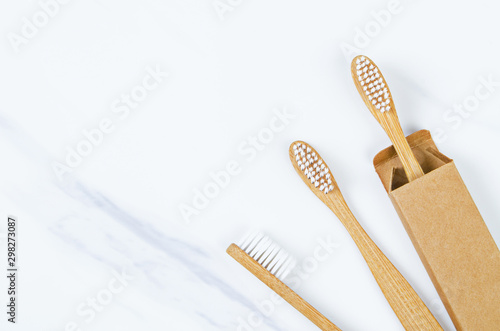 Bamboo toothbrushes on marble background.