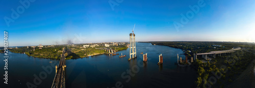Aerial Panorama view of Incomplete Automobile Bridge and Arch Bridge in the Background of Industrial City. © ronedya