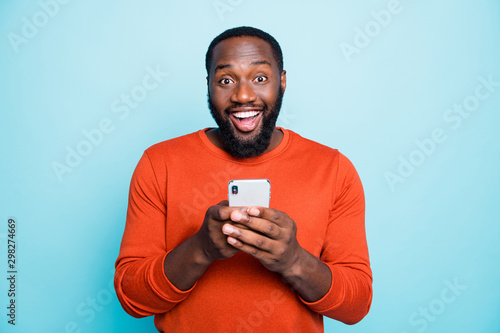 Photo of positive cheerful handsome black man smiling toothily excited about positive news known isolated vivid blue color background photo