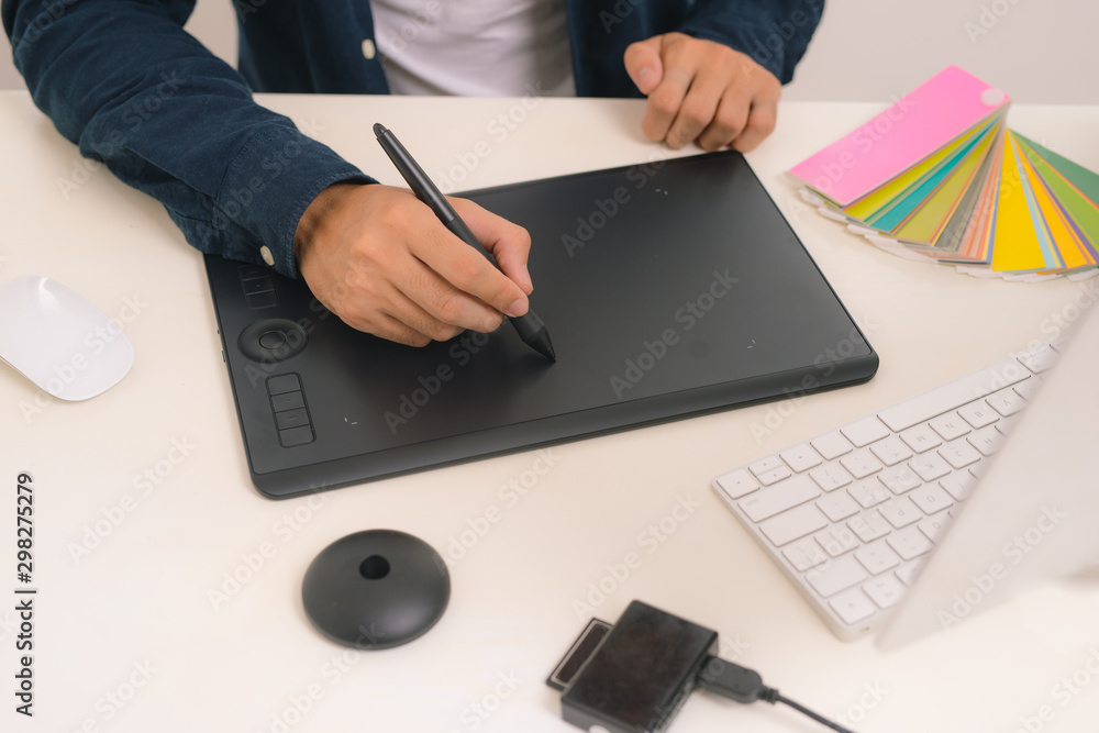Graphic designer drawing on graphics tablet at workplace Graphic designer drawing on graphics tablet at workplace