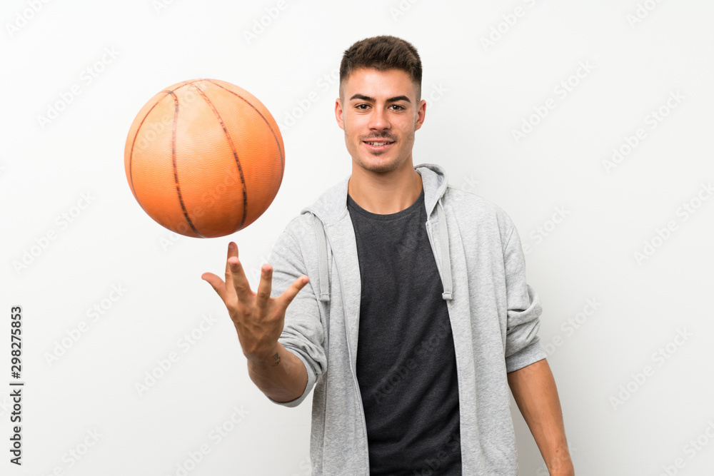Sport man over isolated white wall with ball of basketball
