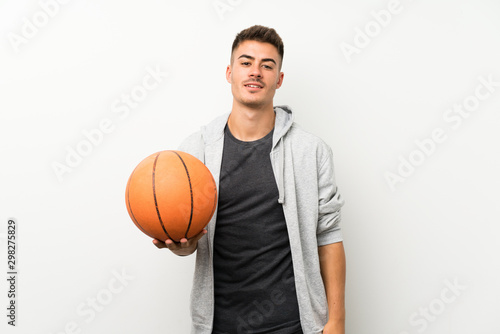 Sport man over isolated white wall with ball of basketball © luismolinero
