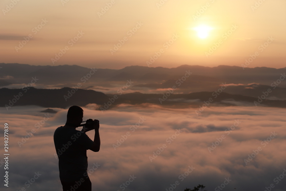 silhouette of man and woman in the morning.And morning mist on the hilltop of Nan province, Thailand.