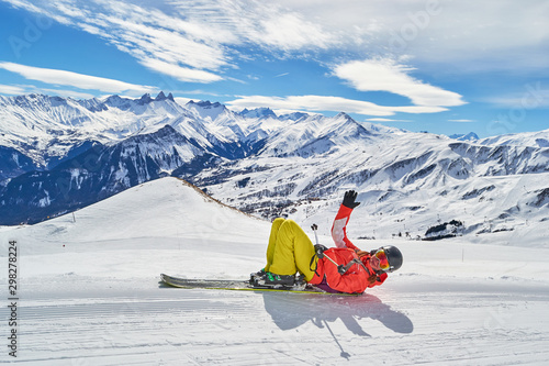 Obraz na płótnie Woman on skis posing at Les Sybelles ski domain, on a blue sky sunny day, with Aguilles d Arves peak in the back, along other mountain peaks. w salonie