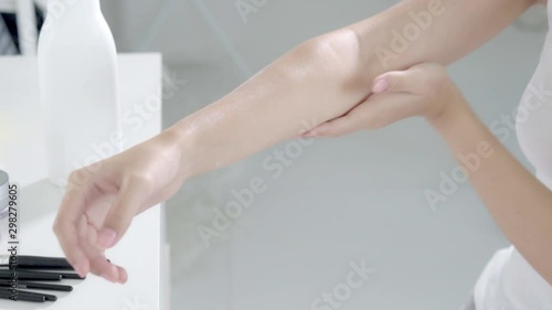 Wallpaper Mural Closeup beautiful young asian woman sitting on a bed stroking hand with soft smooth skin in the bedroom, girl applying body cream and lotion with treatment care, healthy and wellness concept. Torontodigital.ca