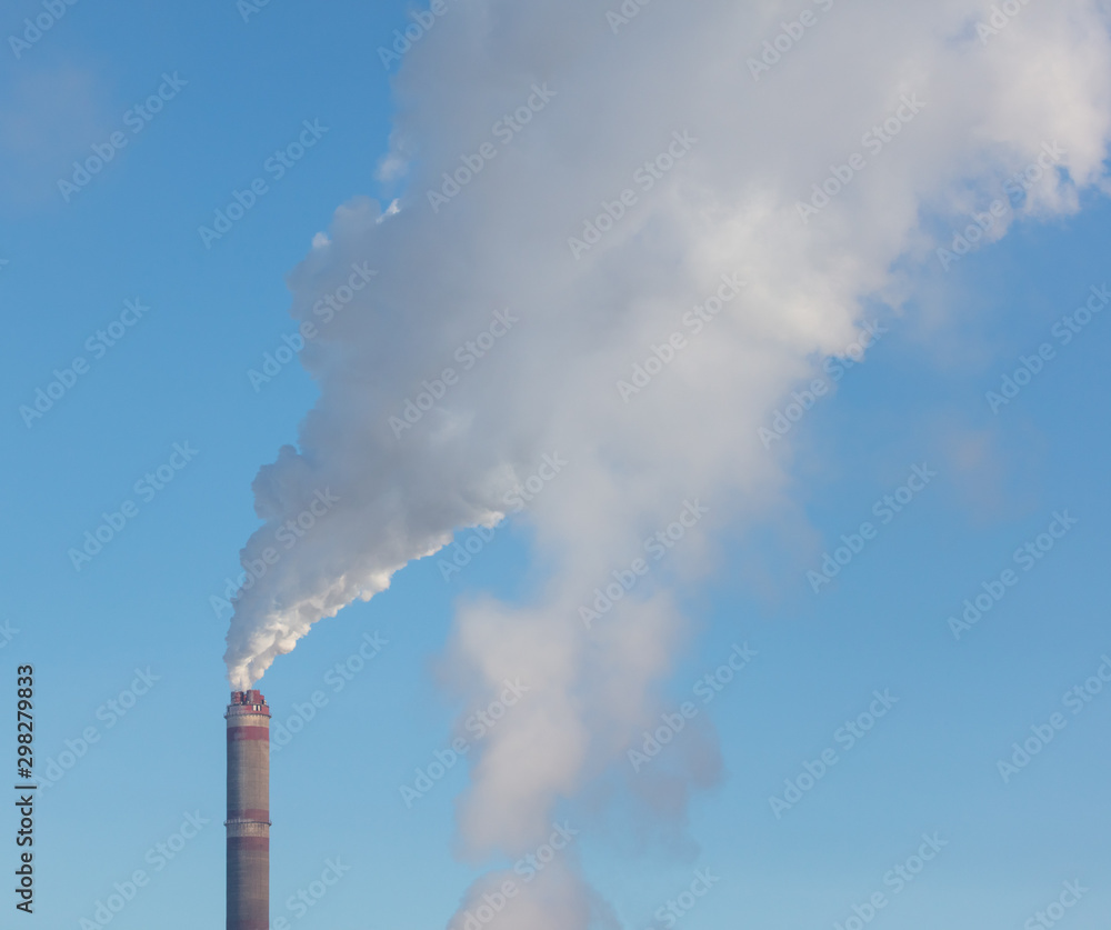 Smoke from a chimney in a factory against a blue sky Smoke from a chimney in a factory against a blue sky