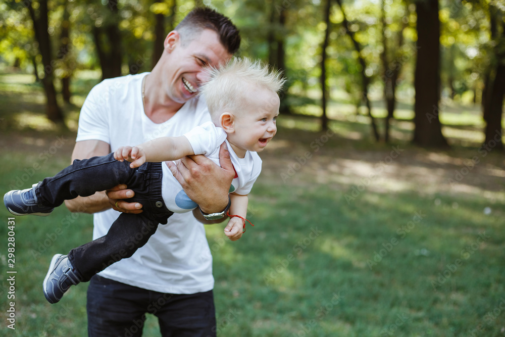Fototapeta premium Young father plays with the child in the park.