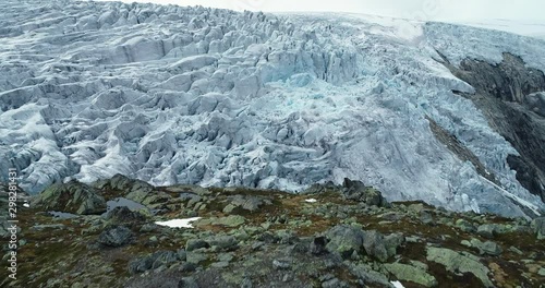 Folgefonna glacier emerges from behind the rocky mountain. Drone flight. Norway. Ice cap. photo