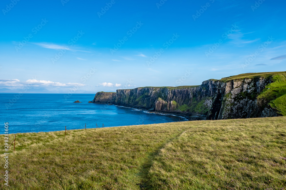 Saftige Weiden unter blauem Himmel an der Küste der Isle of Skye