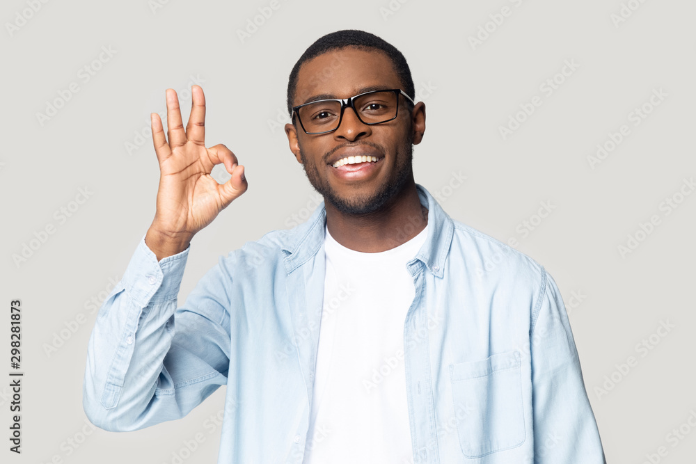 Head shot portrait happy African American man showing ok gesture Head shot portrait happy African American man showing ok gesture