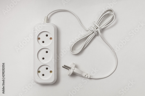 extension cord for three sockets with a long coiled cord on a white background