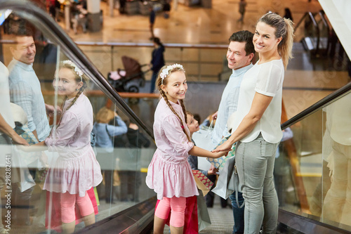 Familie auf Rolltreppe beim Einkaufen