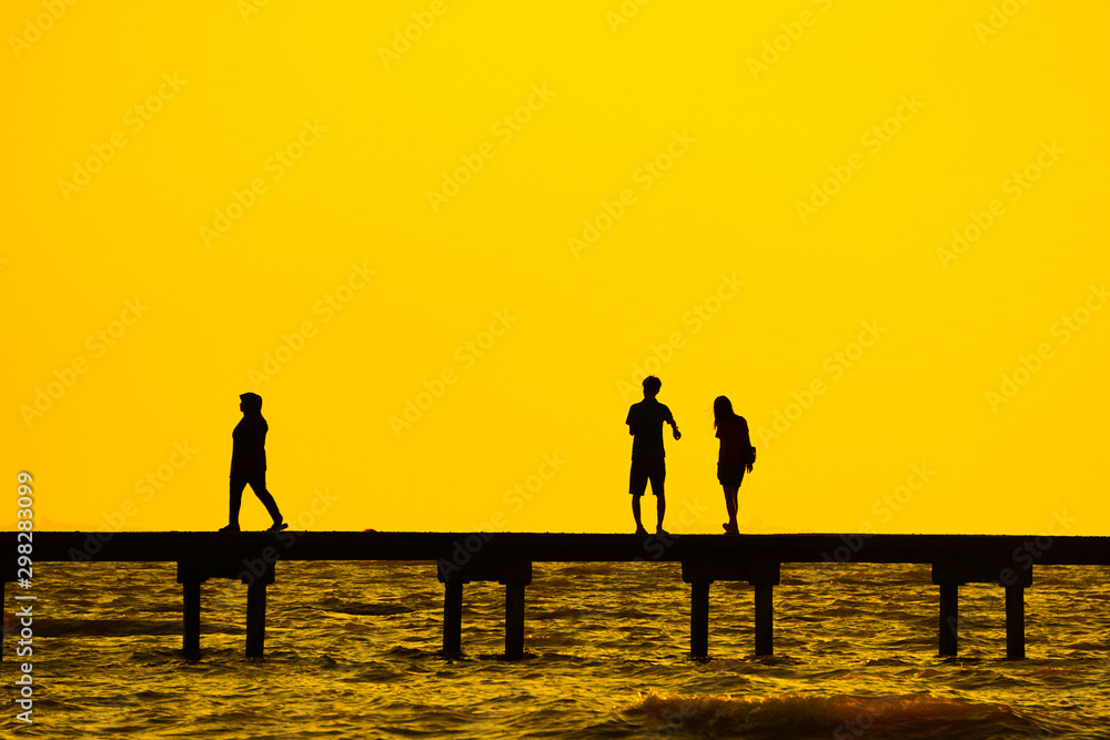 Fototapeta premium silhouette of couples over the long jetty background.