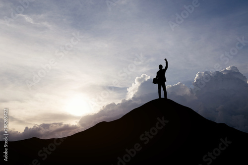 Silhouette of businessman raising his hand to celebrate success on top of mountain, White background.