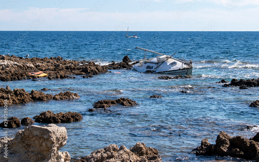 Cala Ratjada Mallorca a sad end to a yacht which lies broken on the rocks as the waves further damage the yacht. 