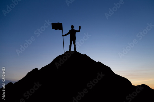 Silhouette of businessman celebrating success on top mountain, sky and sun light background.