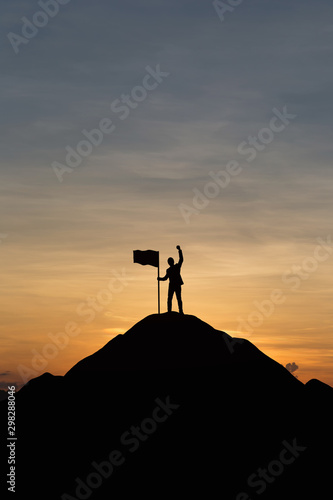 Silhouette of people and flag on top mountain, sky and sun light background. Business success and goal concept.