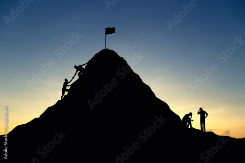 Fotografie Silhouette of successful team and team that failed at sunset background