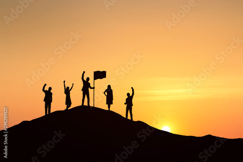 Silhouette of people are celebrating success at the top of the mountain, sky and sun light background. Team business concept. © cofficevit