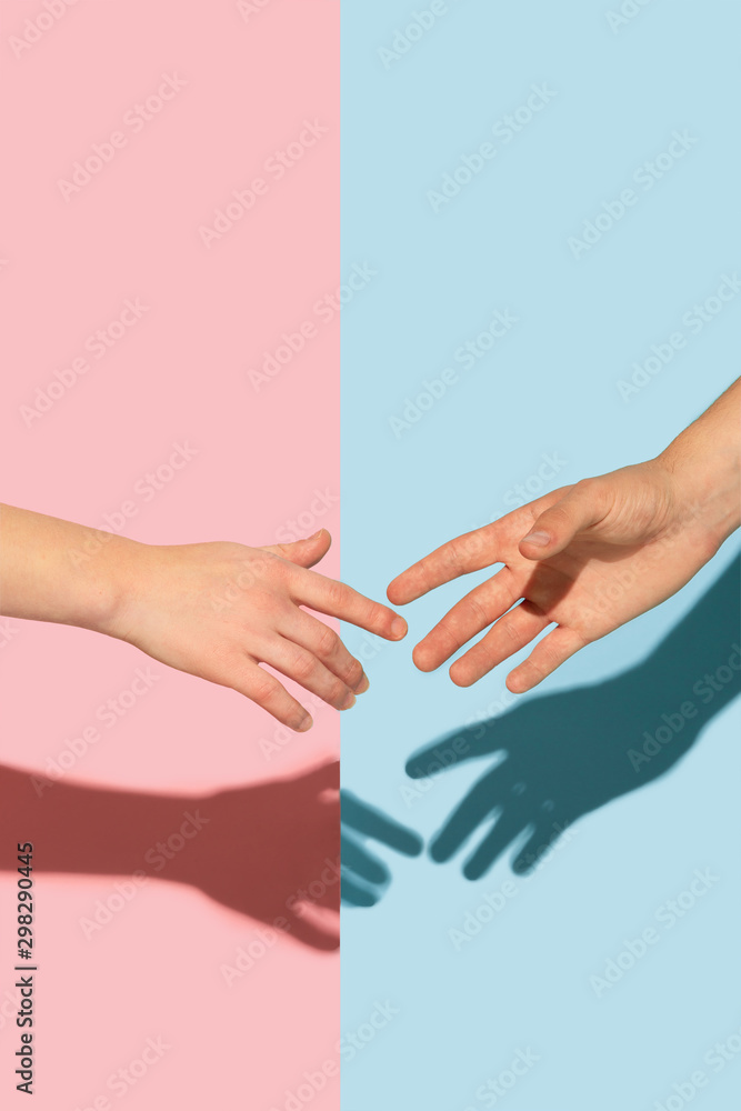 Female and male hands holding on pink and blue background. Concept of human emotions, expession, feelings, relations, ad, love, friendship. Gesturing, meeting, greeting. Female and male hands holding on pink and blue background. Concept of human emotions, expession, feelings, relations, ad, love, friendship. Gesturing, meeting, greeting.