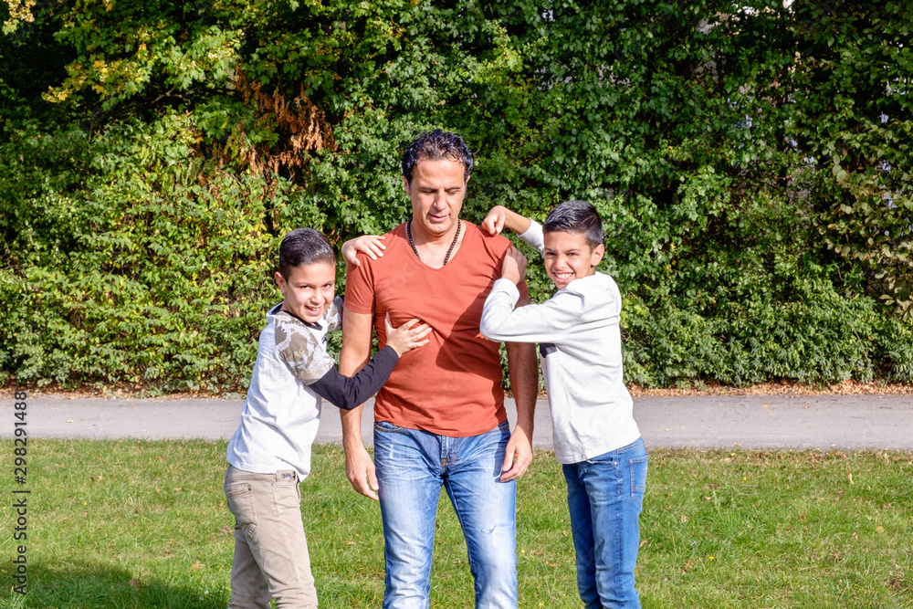 Father and teenage children in walking the park Father and teenage children in walking the park
