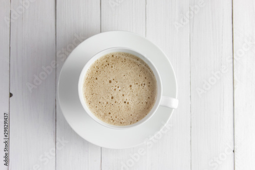 expresso coffee in a white mug on a white wooden background coffee beans around sugar and sweets