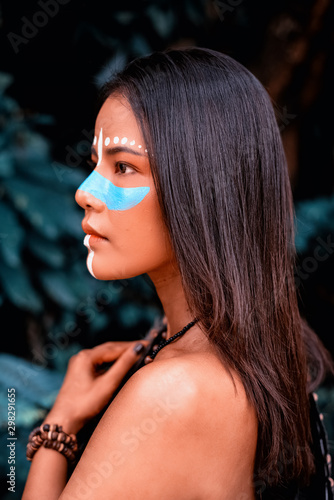 фотографія The beautiful woman paint blue color cross her nose,circle of white color above