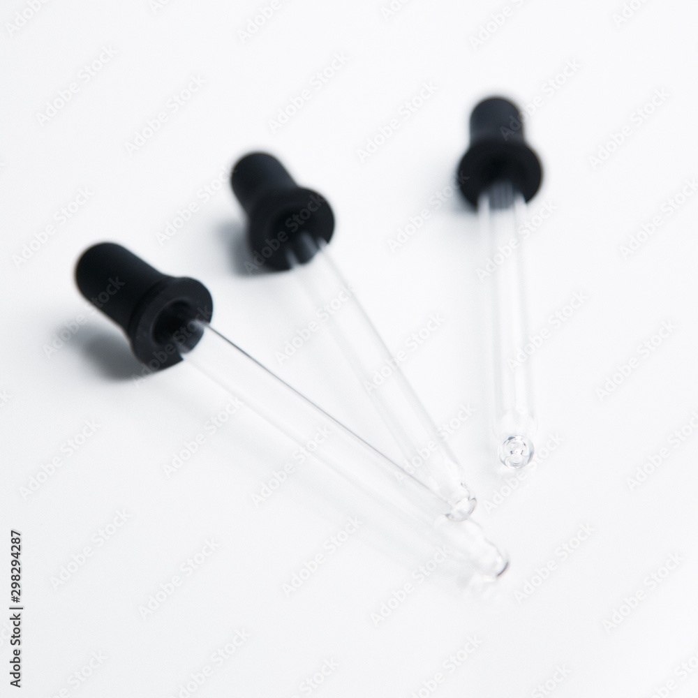Three pipettes for cosmetics. Black eyedropper on a white background. Three pipettes for cosmetics. Black eyedropper on a white background.
