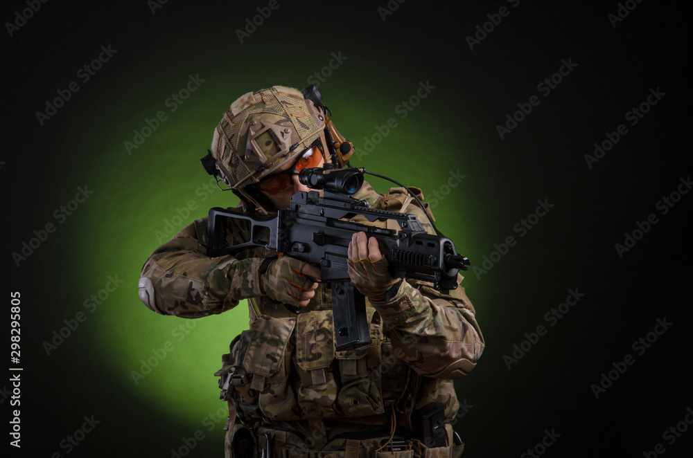 a male soldier in military clothes with a weapon on a dark background a male soldier in military clothes with a weapon on a dark background