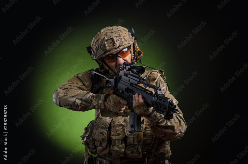 a male soldier in military clothes with a weapon on a dark background a male soldier in military clothes with a weapon on a dark background