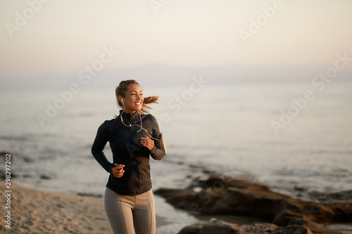 Fototapeta Naklejka Na Ścianę i Meble -  Young happy athletic woman jogging at the beach.