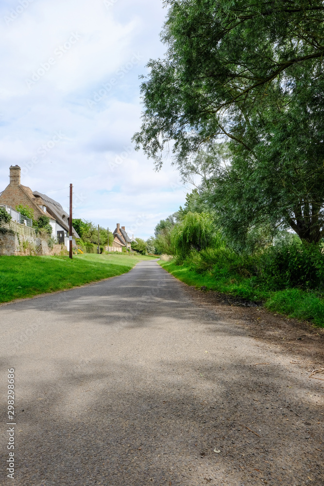 Empty village road seen with distant cottages on the left.