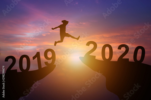 Silhouette of Young man jump between 2019 and 2020 year's. New year Concept.